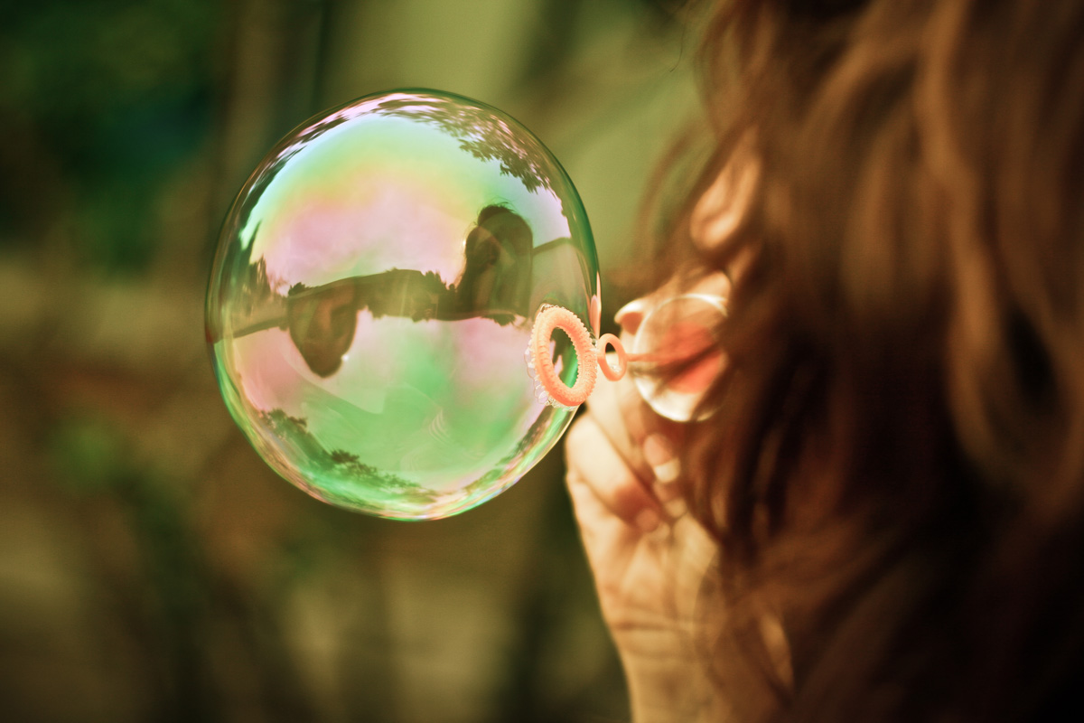 A woman is blowing bubbles with her mouth.