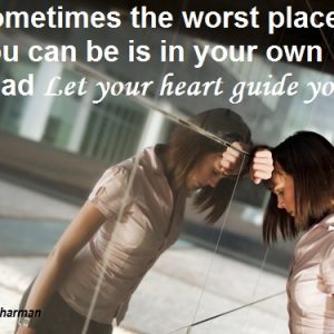 Two women are standing in a mirror and one is holding her head.
